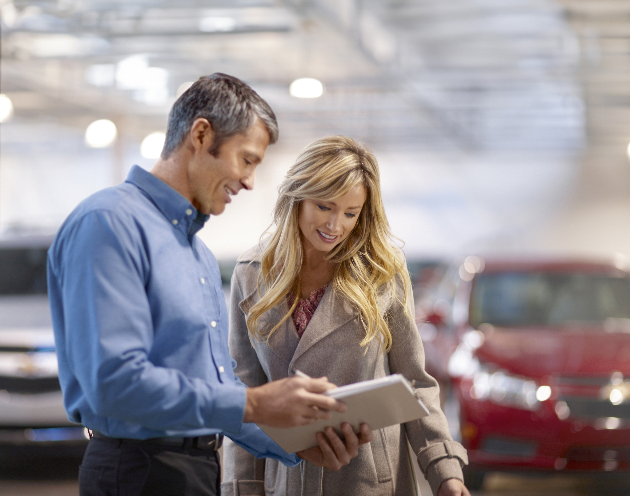 Es geht aber auch persönlich beim Händler des Vertrauens: Verkaufsberater und Kundin im Gespräch über einen Leasingvertrag.