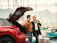 Paar vor Auto mit Gepäck