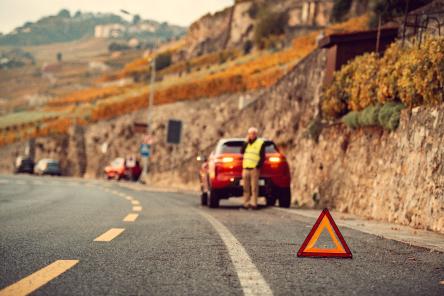 Verkehrssicherheit - Mann mit Autopanne und Pannendreieck