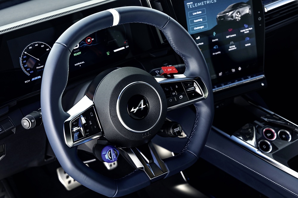 Due pulsanti in alluminio sul volante sono ispirati alla Formula 1: il selettore rotante blu regola il grado di recupero energetico, mentre il pulsante rosso OV controlla il boost per i sorpassi e il Launch Control.