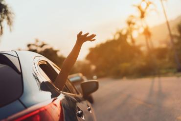 Hand ausgestreckt aus dem Auto