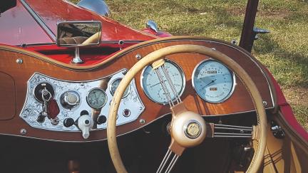 Very british: Holziges Armaturenbrett mit grossen, analogen Anzeigen und weissem Blinkerschalter.